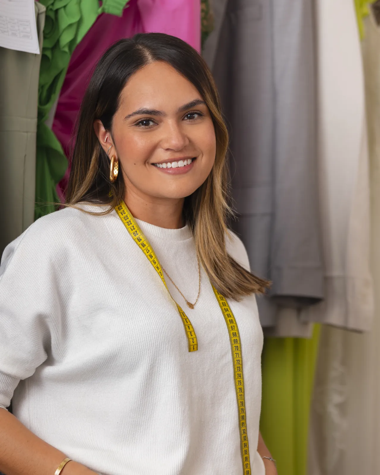 Empreendedora sorrindo no seu ateliê de costura