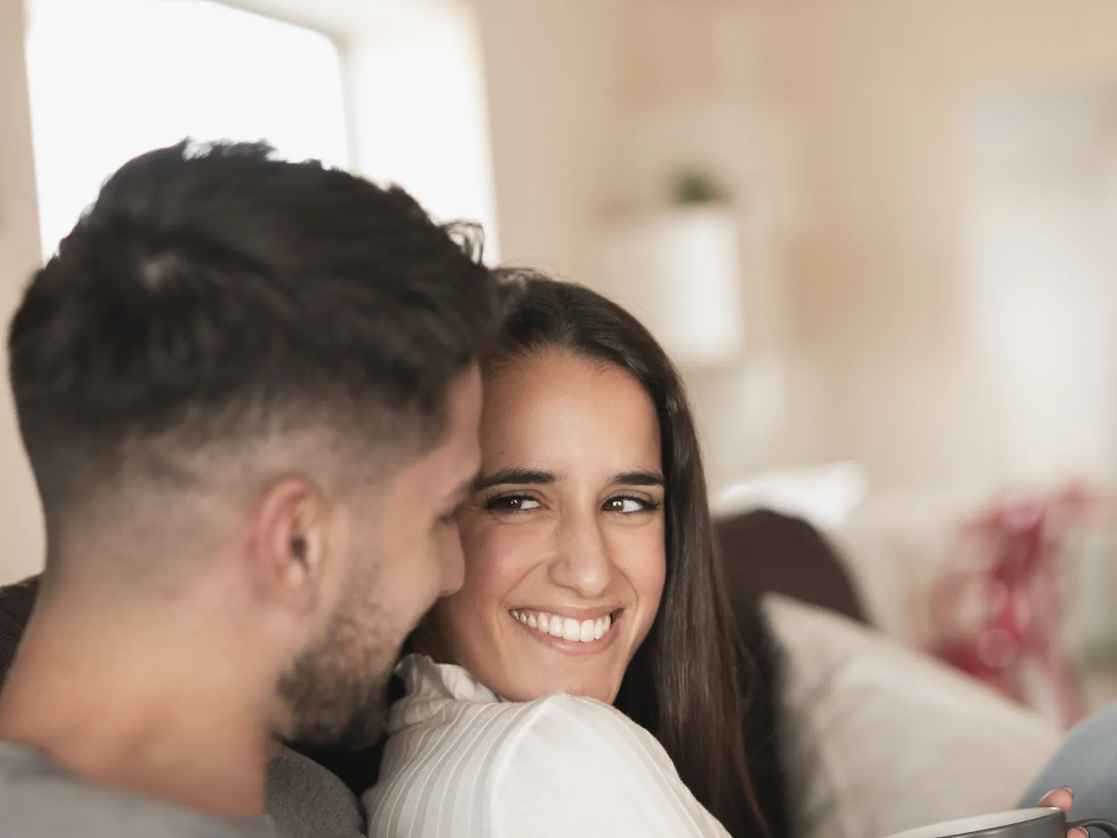 Casal sorrindo junto no sofá